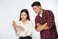 Ilustrasi seorang wanita dan laki-laki sedang menjaga kesehatan mata dari handphone.