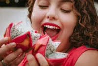 Ilustrasi perempuan sedang makan buah naga.