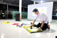 mengolah sampah plastik — Mahasiswa KKN 157 UNS memberikan pelatihan pembuatan dompet dari limbah plastik kepada ibu-ibu di Desa Kajang, Madiun.