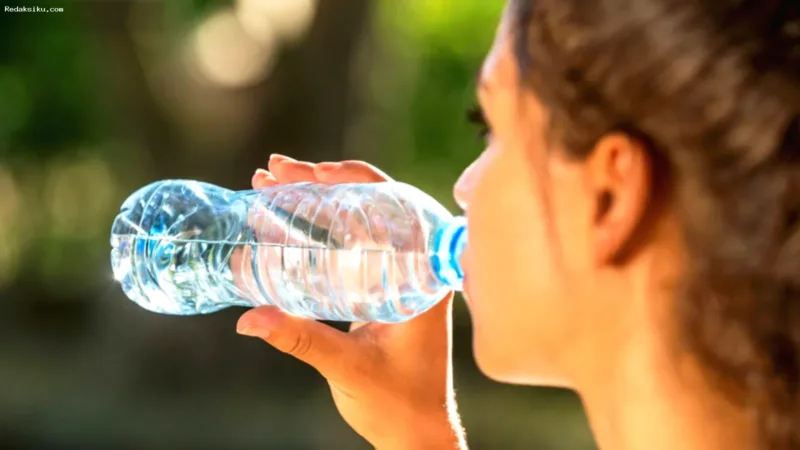 minum air terlalu banyak — Gelas berisi air putih yang melambangkan pentingnya konsumsi cairan sesuai kebutuhan tubuh