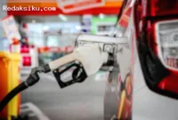 BBM — Petugas SPBU melayani pengisian bahan bakar minyak bersubsidi jenis Pertalite kepada pengendara kendaraan bermotor.
