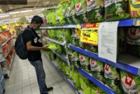 Beras Premium Langka — Rak beras premium yang kosong di ritel modern akibat pemasok tahan pasokan karena HET