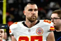 Travis Kelce Korban Skema — Travis Kelce hadir di lapangan mengenakan seragam Kansas City Chiefs.
