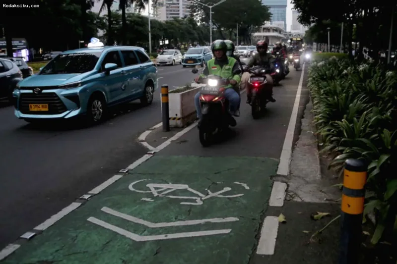 Pesepeda melintasi jalur khusus di jalan raya Jakarta yang dipertahankan oleh Pemprov DKI.