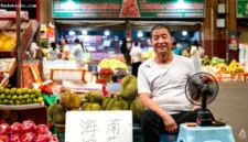 Pedagang buah Qin Chunchang sedang menata durian di kiosnya di Pasar Grosir Buah Hongxingang, Sanya, China.