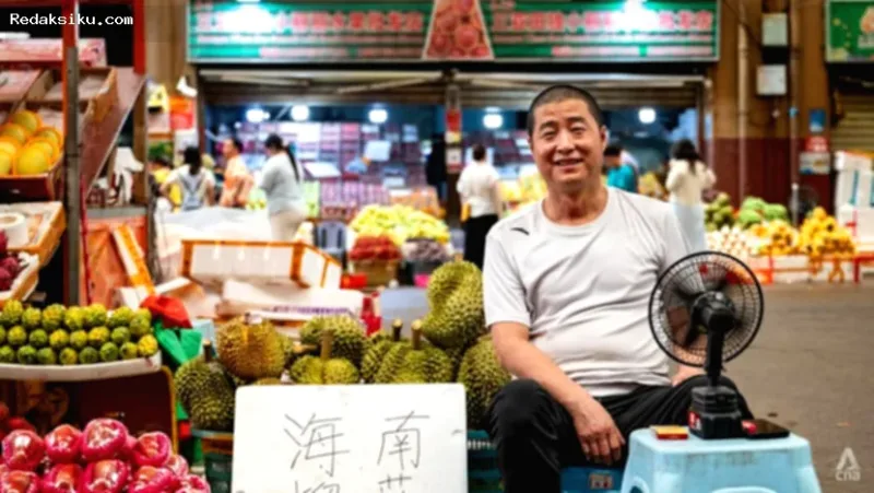 budidaya durian — Pedagang buah Qin Chunchang menata durian di kiosnya di Pasar Grosir Buah Hongxingang, Sanya, China.