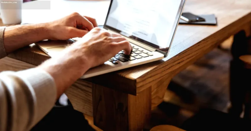 mengubah mindset blogger — Seorang penulis blog yang sedang fokus bekerja di depan laptop untuk mengembangkan strategi konten monetisasi