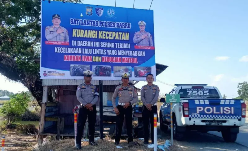 Foto: AKP Herman bersama personel Satlantas memasang spanduk di Pancana.