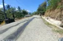 Foto : redaksiku.com. Debu menyelimuti Jalan Doi-Doi–Wanawaru–Barang hingga warga harus menyiramnya setiap hari.