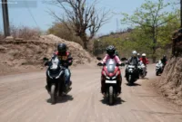 tips safety riding — Anggota komunitas motor Honda melakukan konvoi tertib di jalan raya dengan memakai perlengkapan keselamatan berkendara.