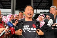 Sidang Perdana Roy Suryo — Roy Suryo menjalani sidang perdana kasus dugaan fitnah ijazah Jokowi di Pengadilan Negeri Jakarta Timur