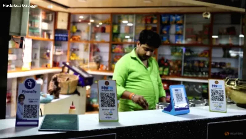 Dampak Aturan Pembayaran — Seorang pelanggan memindai kode QR untuk pembayaran digital di restoran India.
