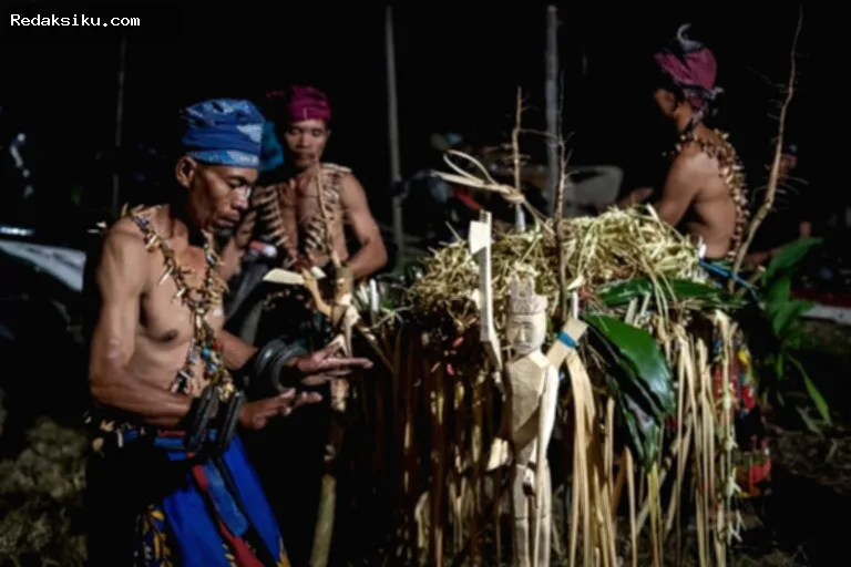 Warga Muara Kate duduk tenang menyaksikan ritual adat Belian di malam hari dengan iringan musik tradisional.