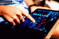 Aplikasi investasi saham di layar ponsel pintar untuk mengelola portofolio investor pemula.