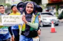 Fitriani Dwi Kurniasari membagikan krisan putih dalam aksi damai menuntut kejelasan hukum atas kematian gajah Rahman.