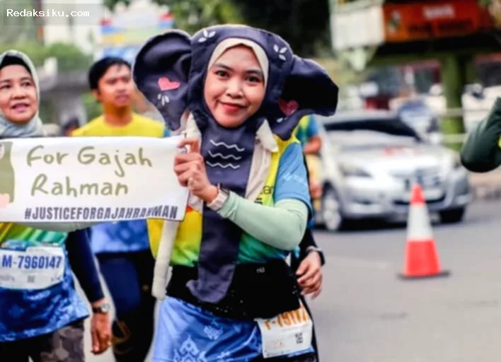 Kisah Fitriani — Fitriani membagikan krisan putih dalam aksi damai menuntut keadilan kematian gajah Rahman.