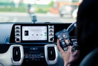 upgrade audio mobil — Teknisi sedang memeriksa sistem kelistrikan mobil listrik untuk pemasangan aksesori audio tambahan