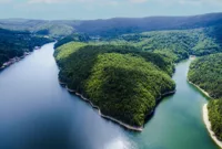 Bahaya Debu Vulkanik — Tumpukan debu vulkanik menempel di bodi dan kaca mobil yang terparkir di area terdampak letusan gunung berapi.