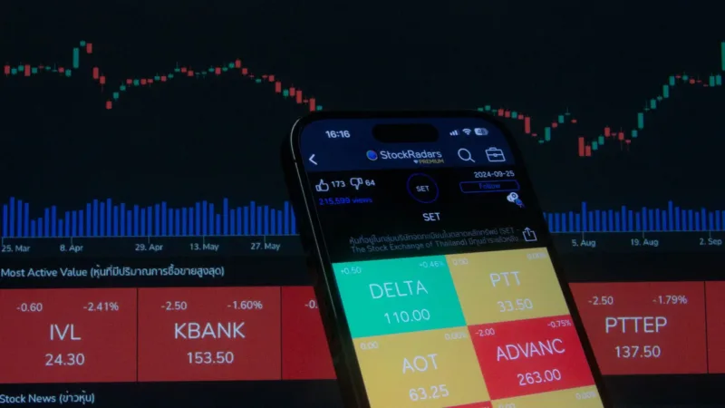 Biaya Transaksi UPI — Layar ponsel menampilkan aplikasi pembayaran digital dengan grafik pasar saham