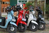Motor Pelanggan Alfamidi — Sepeda motor pelanggan terparkir di pinggir jalan depan gerai Alfamidi Al Mubarok setelah dipindahkan oleh juru parkir.
