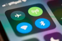 Wi-Fi Publik — Seseorang menggunakan iPhone di tempat umum dengan latar belakang kedai kopi.