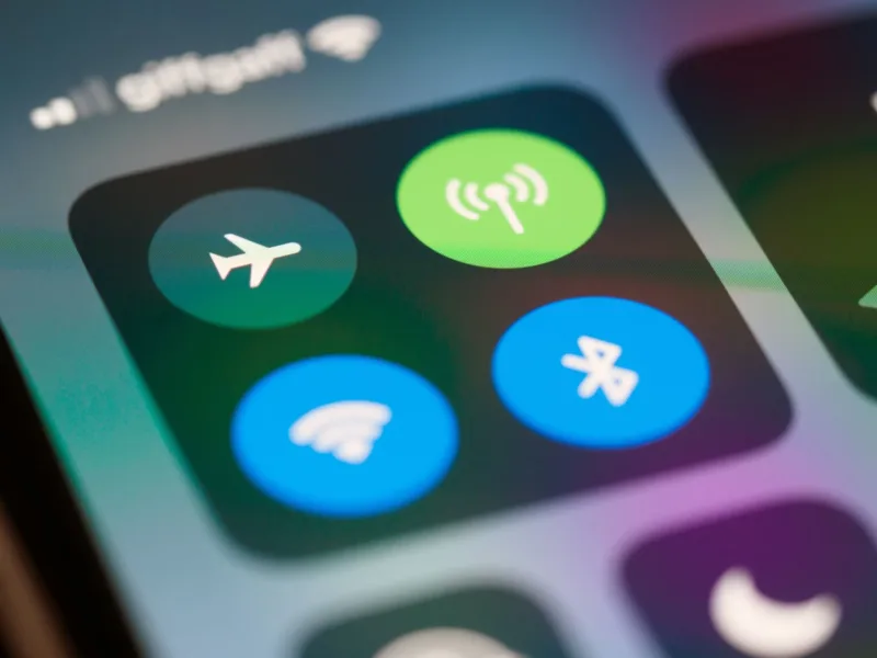 Wi-Fi Publik — Seseorang menggunakan iPhone di tempat umum dengan latar belakang kedai kopi.