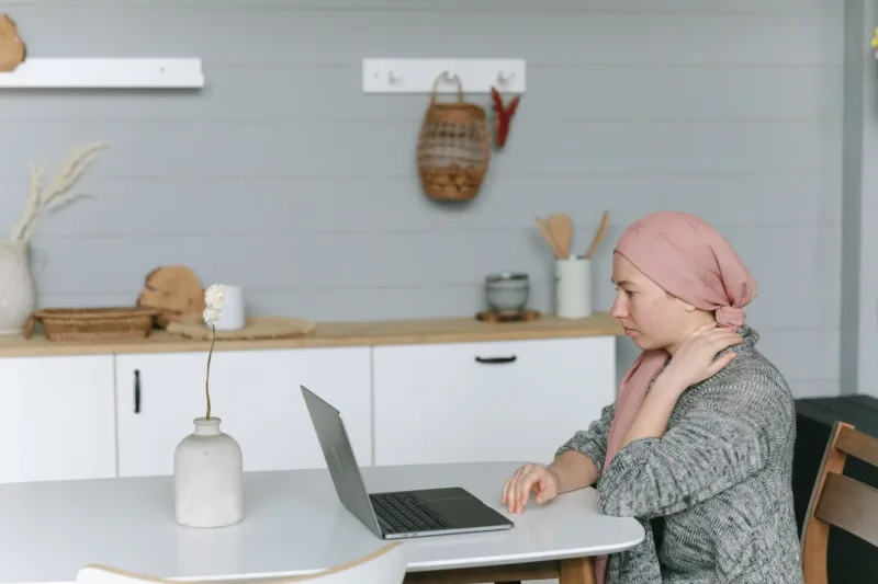Risiko Kesehatan Akibat Terlalu — Seorang pekerja kantoran duduk berjam-jam menatap layar laptop tanpa jeda di meja kerja